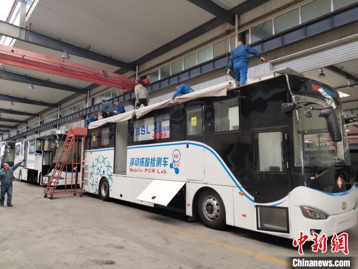 工人在組裝5G智能移動核酸檢測車車頂設備。 王鵬 攝